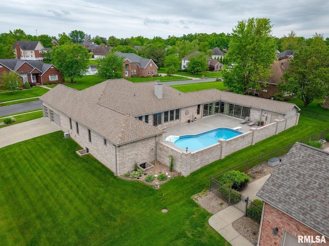 view of swimming pool with a yard, fence, a residential view, and a fenced in pool