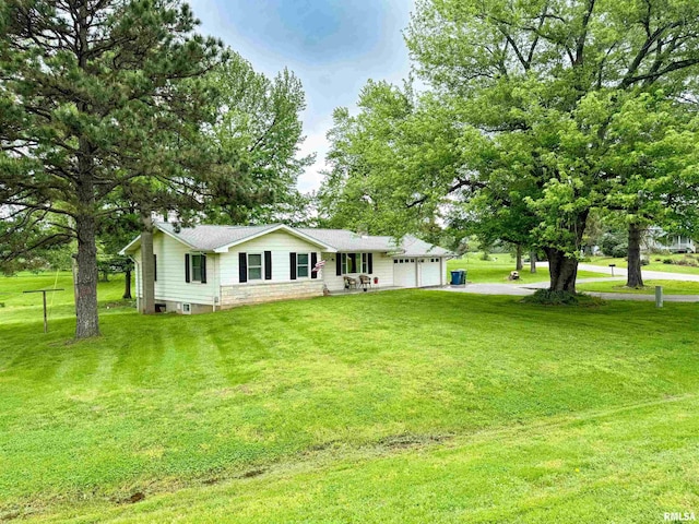 back of house featuring a lawn, an attached garage, and aphalt driveway