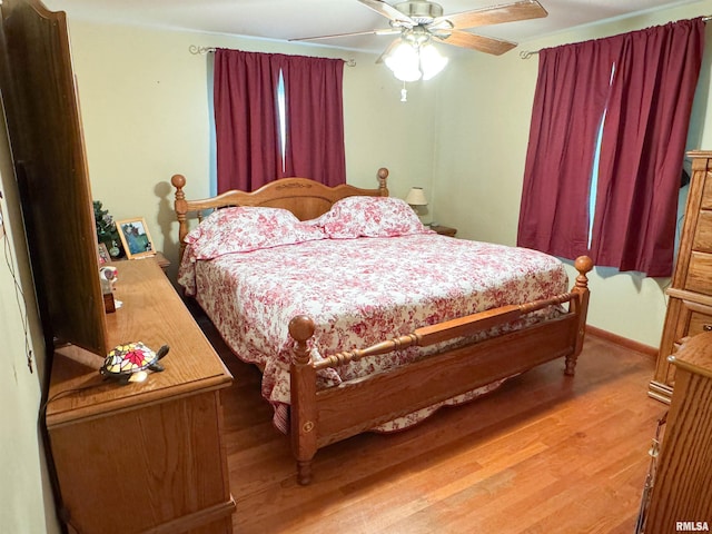 bedroom featuring baseboards, a ceiling fan, and light wood-style flooring