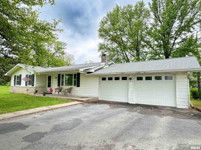 ranch-style house featuring a garage, aphalt driveway, a front yard, a chimney, and a porch