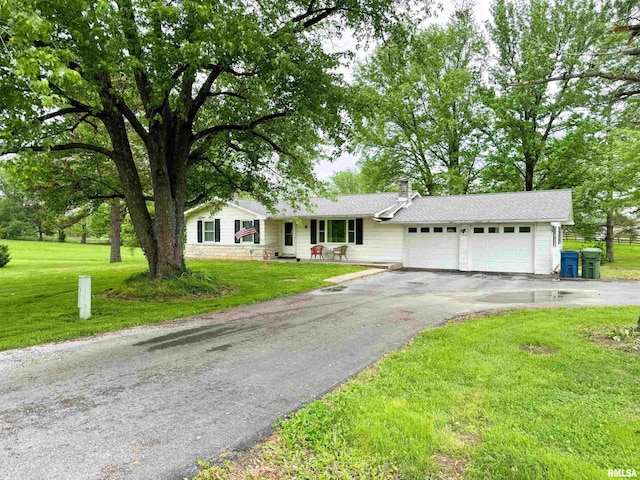 single story home featuring an attached garage, a chimney, driveway, and a front yard