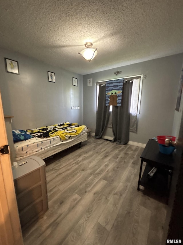 bedroom featuring a textured ceiling and wood finished floors