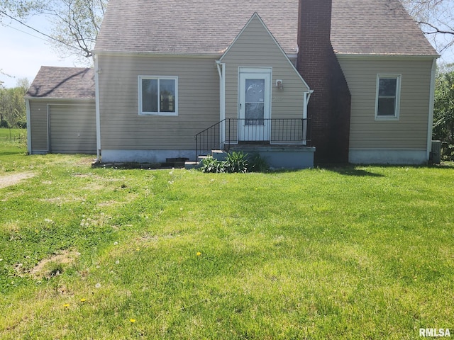 view of front of home featuring central AC, a chimney, a shingled roof, and a front lawn