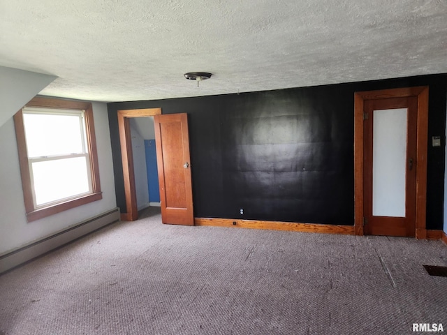 carpeted spare room featuring baseboards, baseboard heating, and a textured ceiling