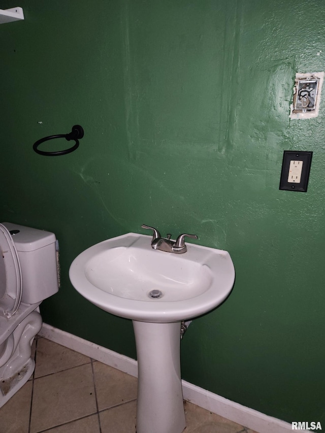 bathroom featuring toilet, tile patterned floors, and baseboards