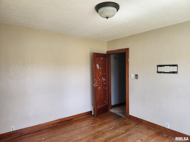 unfurnished room with baseboards and wood finished floors