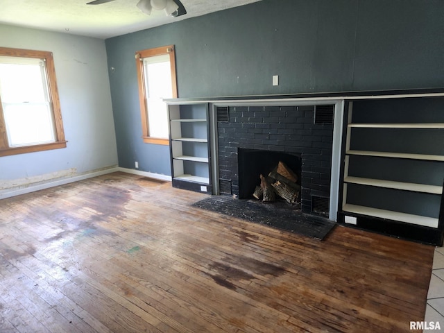 unfurnished living room with a healthy amount of sunlight, a ceiling fan, and wood finished floors