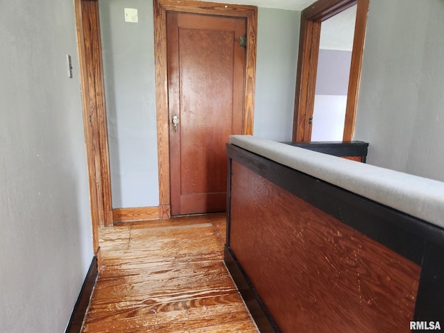 hall with baseboards and light wood finished floors