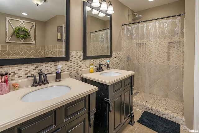 full bath with a tile shower, tile patterned flooring, two vanities, and a sink