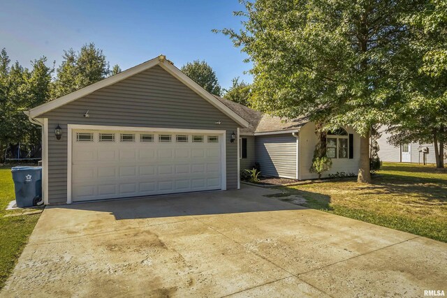 view of front of home with a front yard and a garage