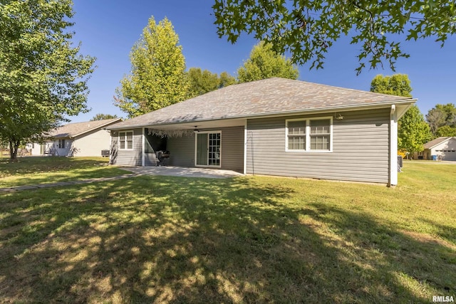 back of house with a yard, a patio, and a shingled roof