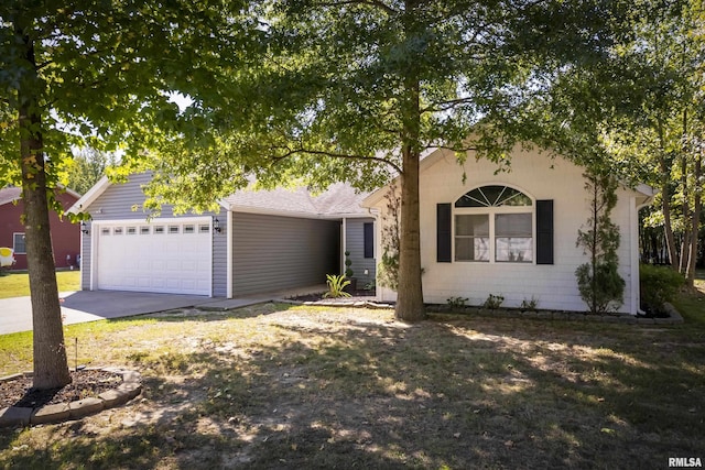 view of property hidden behind natural elements featuring driveway and a garage
