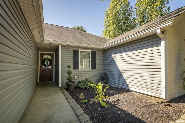entrance to property with roof with shingles