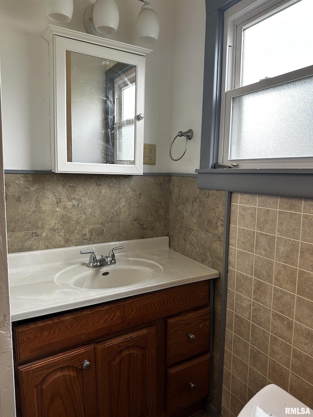 half bath with tile walls and vanity