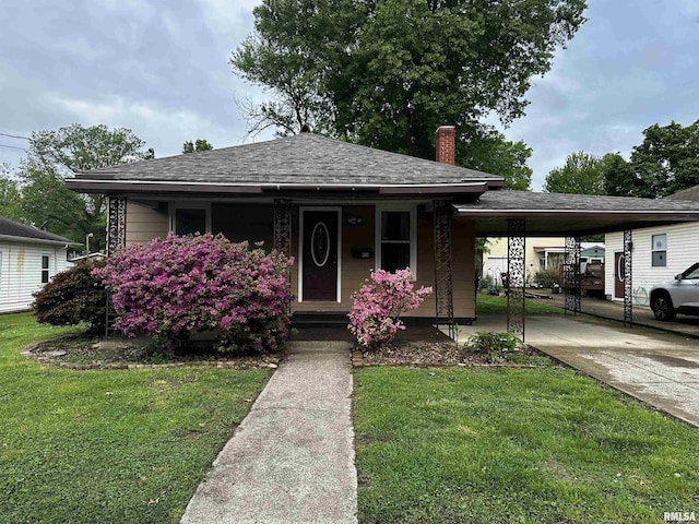 bungalow-style house with a front lawn, concrete driveway, a porch, and a carport