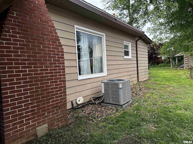 view of side of home with a yard and cooling unit