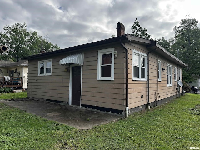 exterior space featuring a chimney, a yard, and crawl space