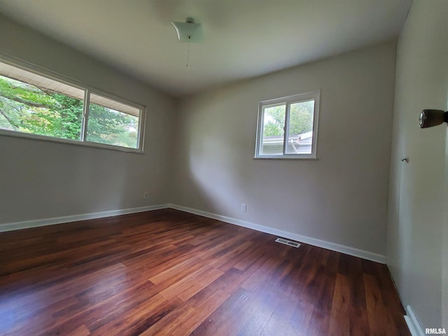 1027 W Laurel St, Carbondale, IL 62901 - spare room with baseboards, dark wood finished floors, visible vents, and plenty of natural light