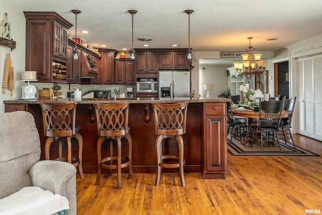 24 Karen Dr, Christopher, IL 62822 - kitchen featuring light wood-style flooring, glass insert cabinets, an inviting chandelier, a peninsula, and stainless steel appliances