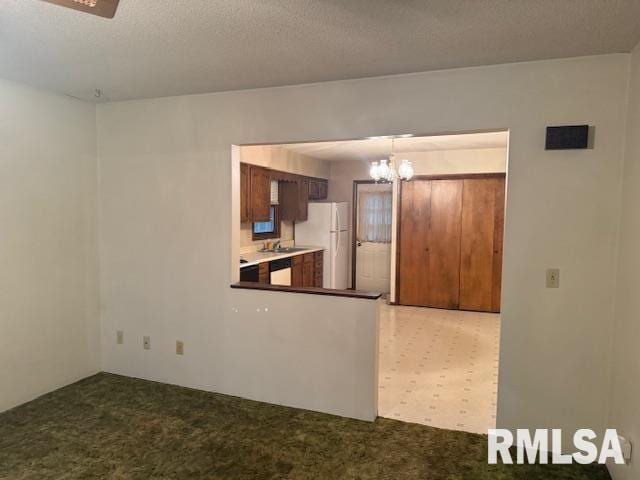 kitchen with freestanding refrigerator, a notable chandelier, visible vents, dishwashing machine, and light colored carpet