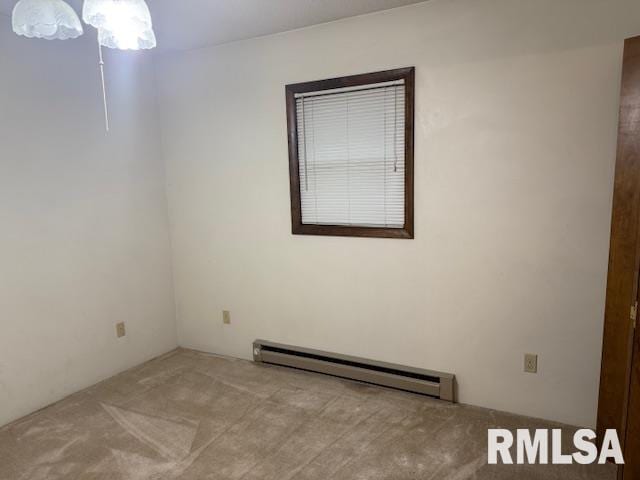 carpeted empty room with a baseboard radiator