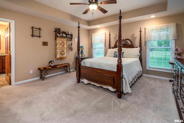 bedroom with recessed lighting, carpet flooring, a raised ceiling, connected bathroom, and baseboards