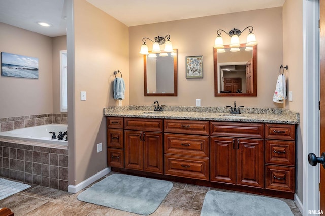 bathroom featuring double vanity, baseboards, a garden tub, and a sink