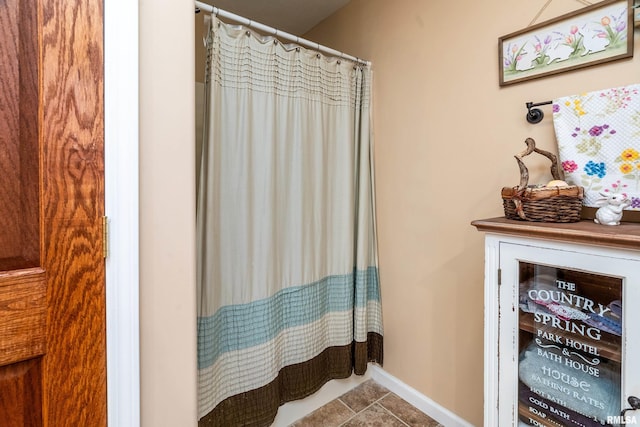 full bath with tile patterned flooring, a shower with curtain, and baseboards