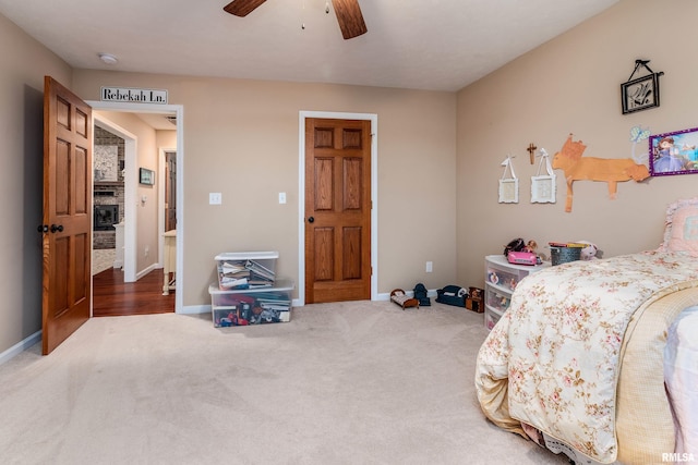 carpeted bedroom with ceiling fan and baseboards