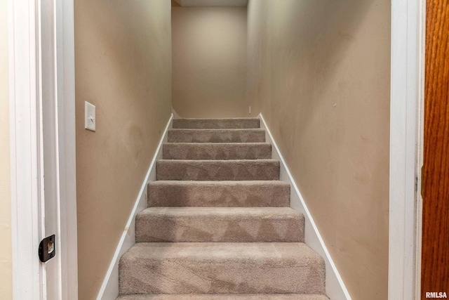 staircase with baseboards and carpet floors