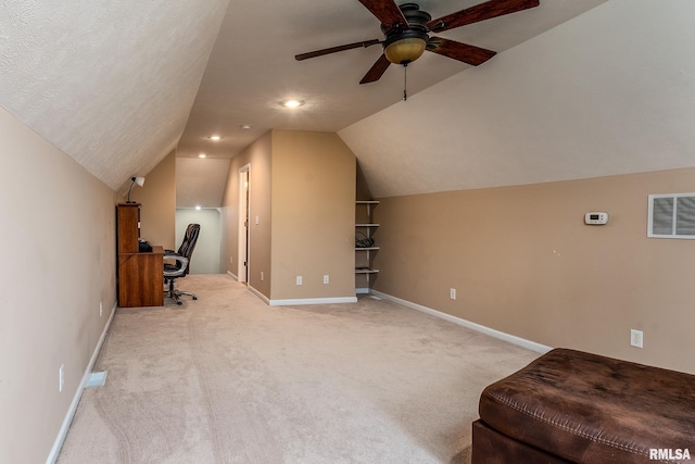 office area featuring lofted ceiling, ceiling fan, light carpet, and visible vents