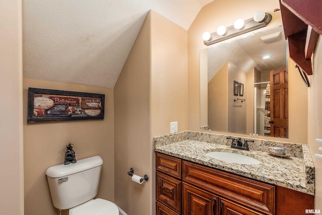bathroom featuring vanity, lofted ceiling, and toilet