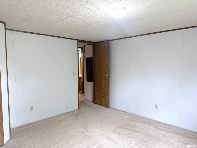 carpeted empty room with a textured ceiling