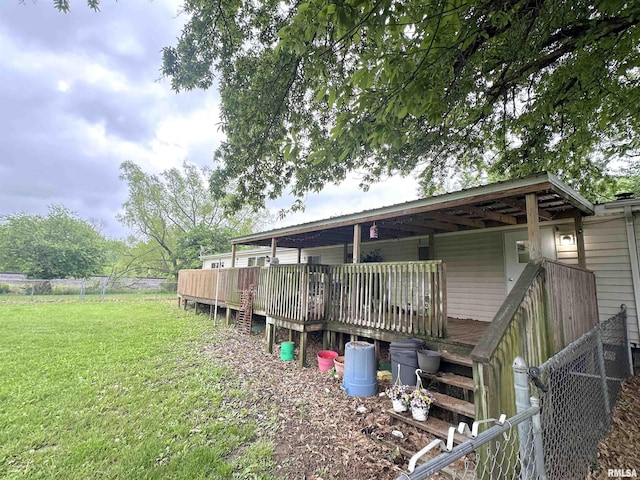 rear view of property featuring a lawn and fence
