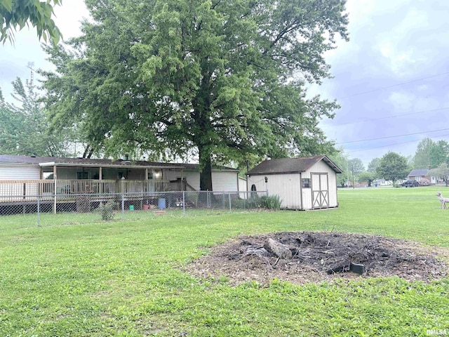 view of yard with an outbuilding, a storage shed, and fence