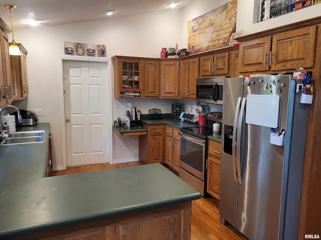 325 W N St, Dix, IL 62830 - kitchen featuring hanging light fixtures, appliances with stainless steel finishes, brown cabinetry, and a sink