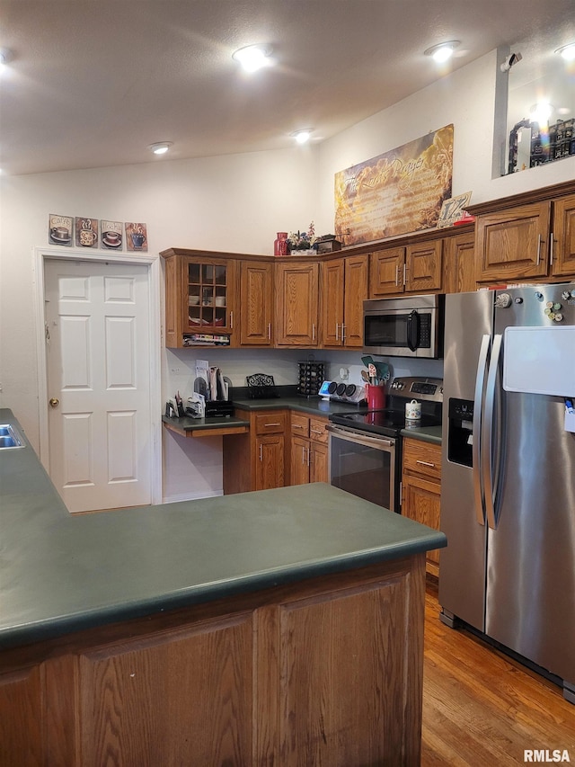 325 W N St, Dix, IL 62830 - kitchen with stainless steel appliances, wood finished floors, brown cabinets, glass insert cabinets, and dark countertops