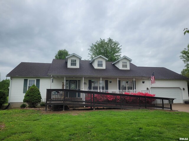 325 W N St, Dix, IL 62830 - new england style home featuring a front lawn, covered porch, a garage, and concrete driveway