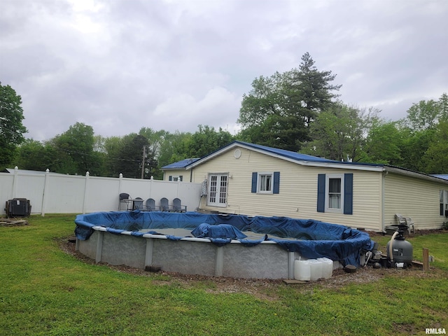 view of swimming pool with french doors, a yard, fence, and a fenced in pool