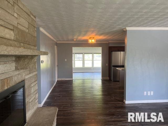 unfurnished living room featuring ornamental molding, baseboards, and dark wood-style floors