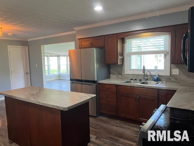 kitchen featuring a sink, freestanding refrigerator, a wealth of natural light, and light countertops