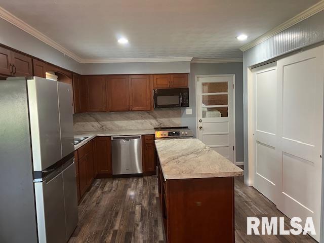 kitchen with stainless steel appliances, a center island, decorative backsplash, light countertops, and dark wood-style floors