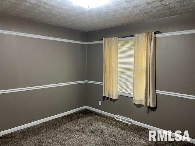 unfurnished room featuring a textured ceiling, baseboards, visible vents, and dark carpet
