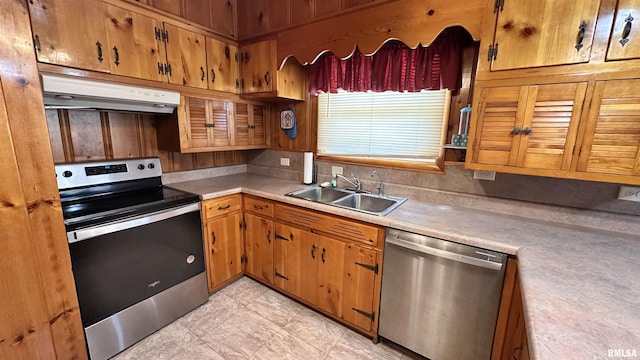 1908 E Oak St, West Frankfort, IL 62896 - kitchen featuring stainless steel appliances, under cabinet range hood, brown cabinetry, a sink, and light countertops