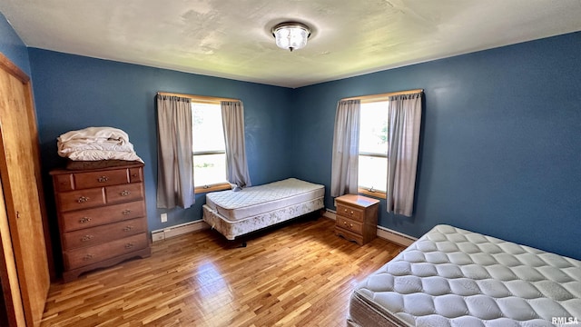 1908 E Oak St, West Frankfort, IL 62896 - bedroom with light wood finished floors, baseboards, and a baseboard heating unit