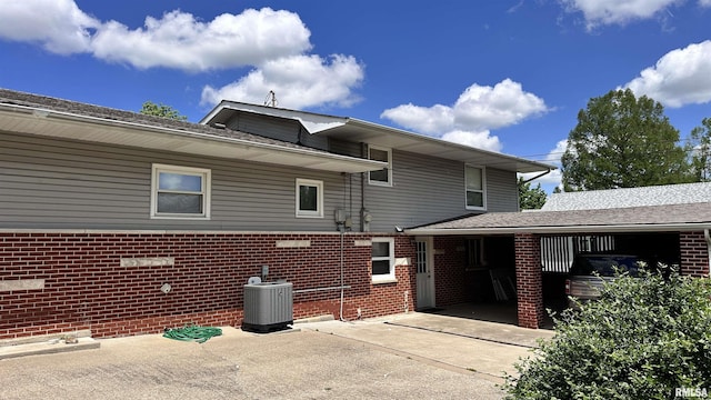1908 E Oak St, West Frankfort, IL 62896 - view of home's exterior with a shingled roof, brick siding, a patio area, and central AC