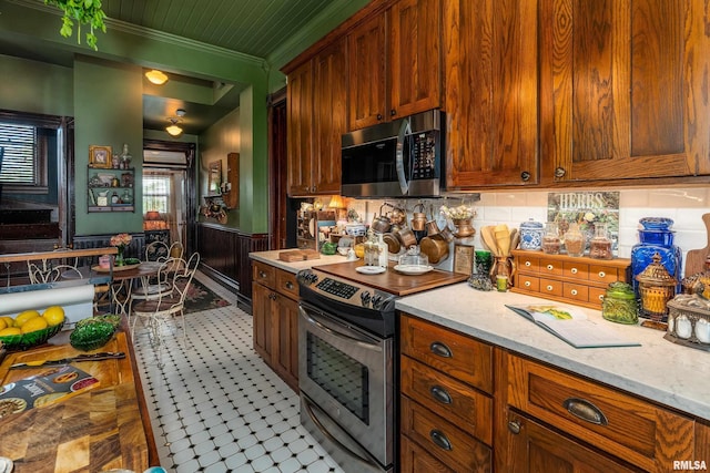 301 W High St, Anna, IL 62906 - kitchen with stainless steel appliances, crown molding, tasteful backsplash, light stone countertops, and tile patterned floors