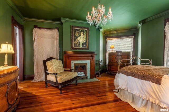 301 W High St, Anna, IL 62906 - bedroom featuring crown molding, a chandelier, hardwood / wood-style flooring, and a fireplace