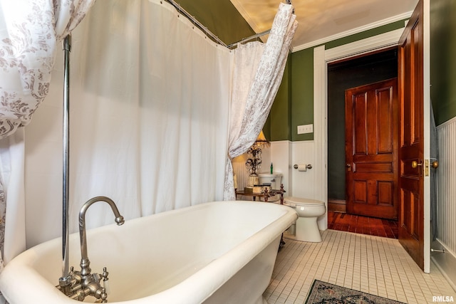 301 W High St, Anna, IL 62906 - full bathroom with a soaking tub, toilet, wainscoting, and tile patterned floors