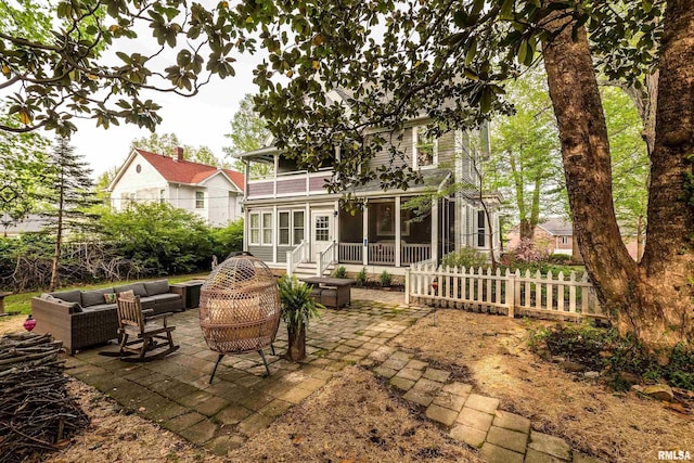 301 W High St, Anna, IL 62906 - rear view of house with an outdoor living space, a sunroom, a patio, fence, and a balcony